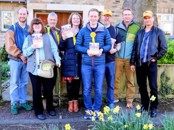 A group of middle-aged people holding pamphlets. 