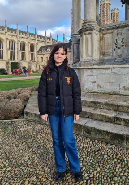 A young woman in front of a large fountain. 