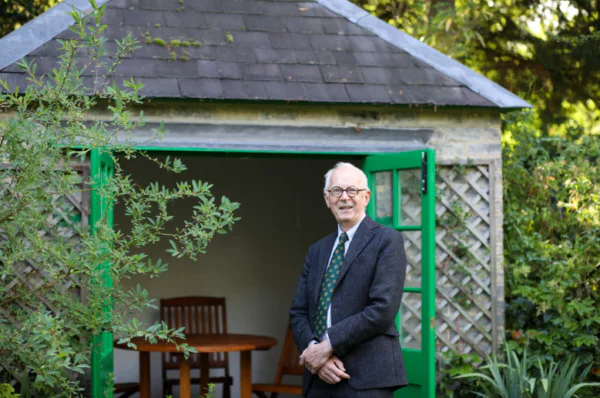 Man in a suit beside a summer house