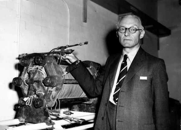 A black and white image of a man with some equipment. 