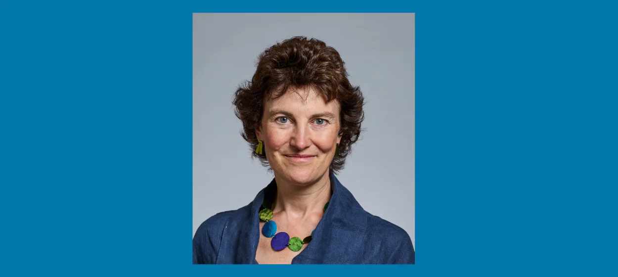 Portrait photo of Professor Fitzgerald in blue shirt on a blue background.