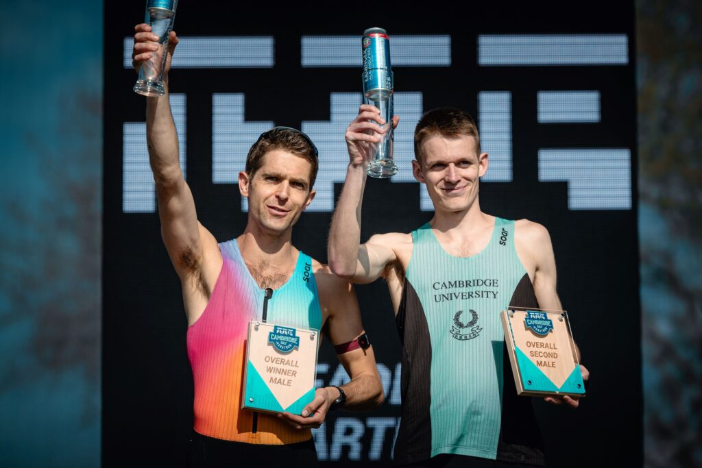 Two people holding glasses aloft and awards