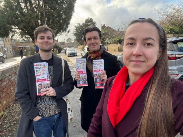 Three people with pamphlets. 