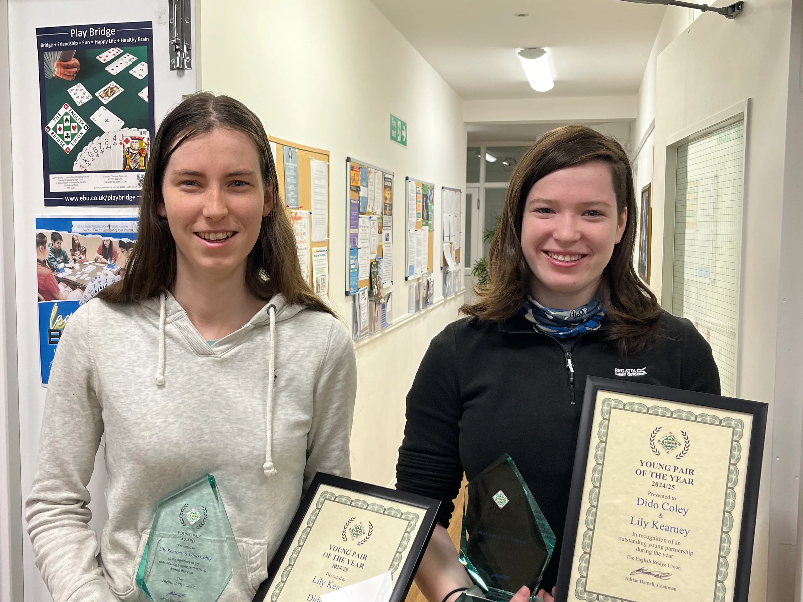 Two young women with a certificate.