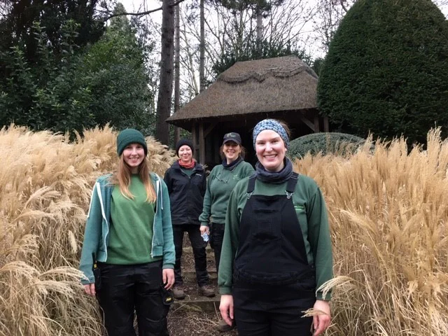 Four gardeners standing in front of a summer house